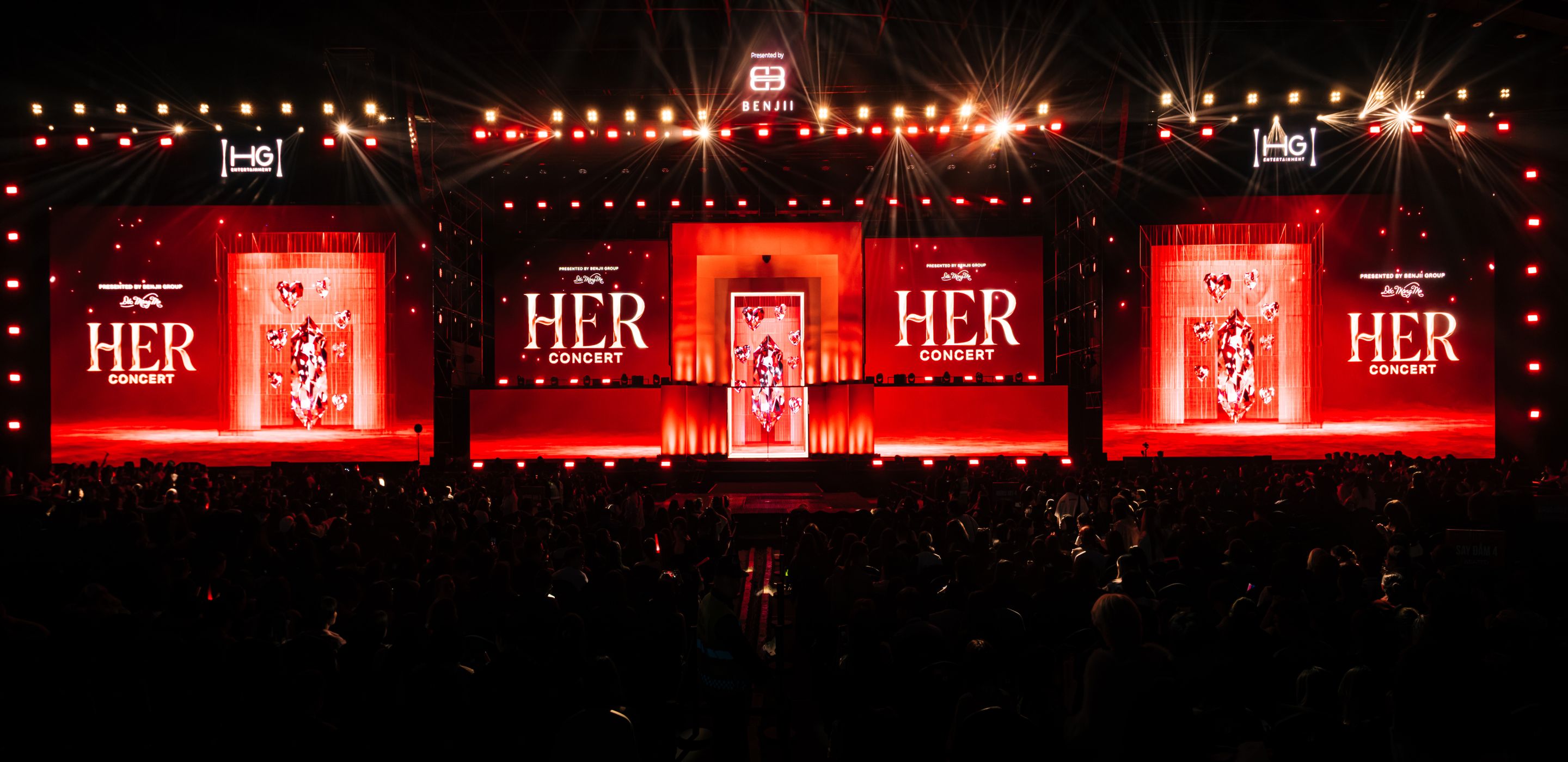 A packed arena facing the HER Concert stage